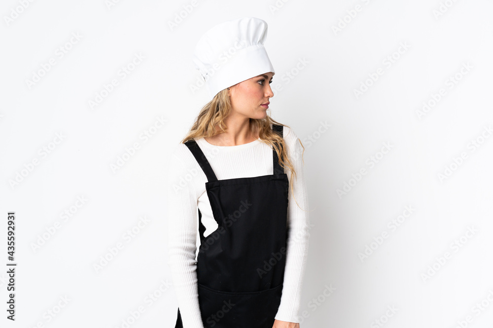 Young Brazilian chef woman isolated on white background looking to the side Young Brazilian chef woman isolated on white background looking to the side