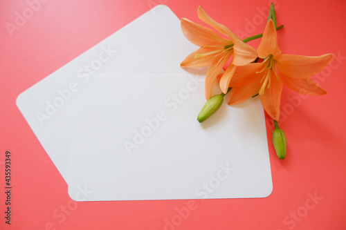 Tropical summer greeting concept. Orange flowers decoration with blank Cards on Red background. Summer greeting card, Tropical message letter, welcome message.