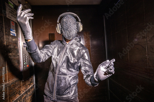 Sparkle masked man dancing in a lift