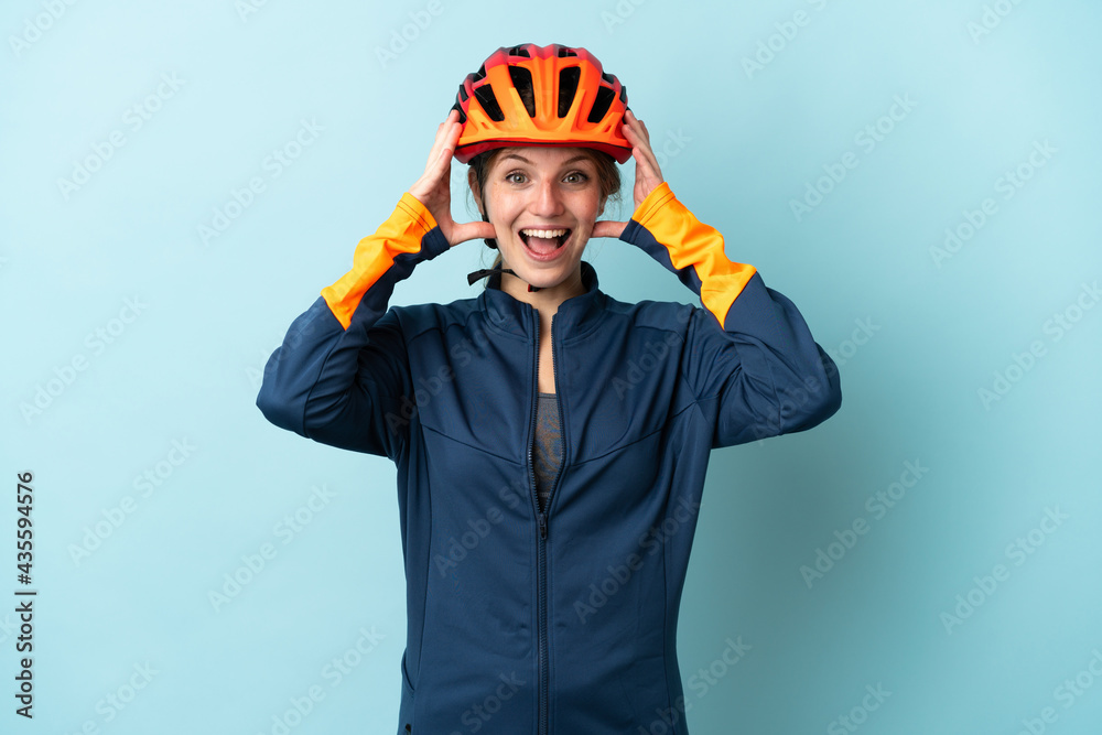 Young cyclist woman isolated on blue background with surprise expression Young cyclist woman isolated on blue background with surprise expression
