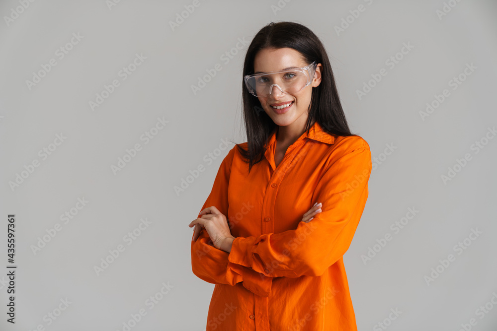 Young brunette woman in safety glasses smiling and looking at camera Young brunette woman in safety glasses smiling and looking at camera