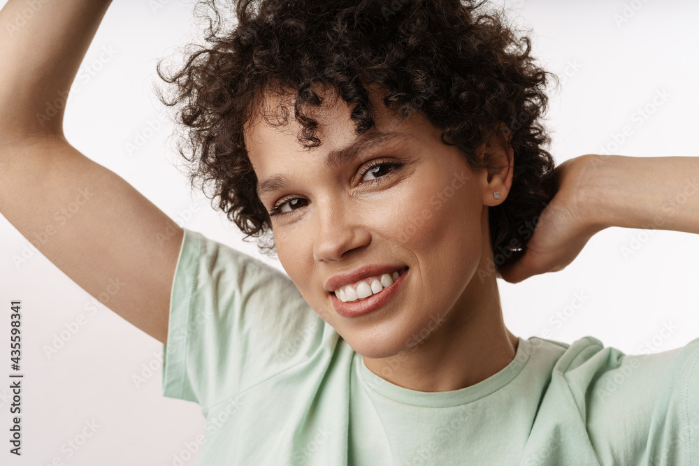 Young curly brunette woman smiling and looking at camera Young curly brunette woman smiling and looking at camera