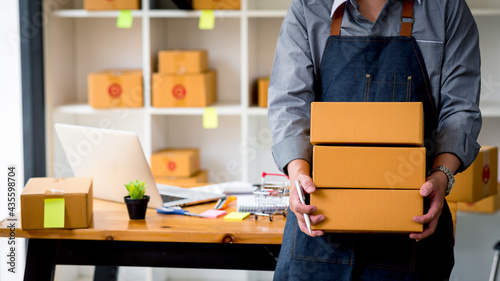 Starting small businesses SME owners man entrepreneurs Write the address on receipt box and check online orders to prepare to pack the boxes, sell to customers, sme business ideas online. photo