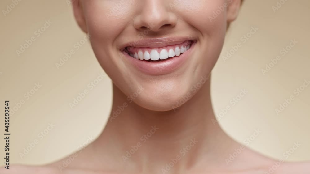 Teeth whitening. Close up shot of young unrecognizable lady widely smiling to camera, showing her perfect smile