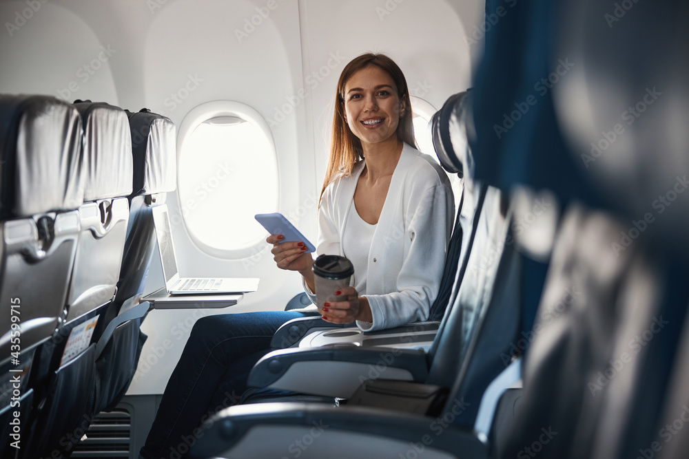 Contented female passenger of the airplane sitting alone Contented female passenger of the airplane sitting alone
