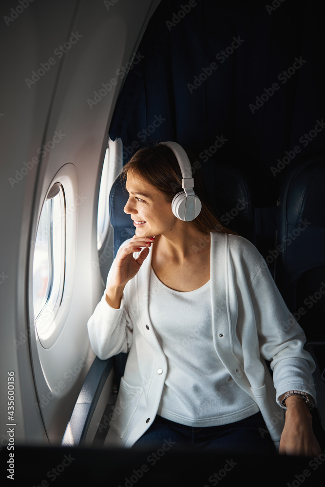 Contented lady looking at the clouds during the flight Contented lady looking at the clouds during the flight