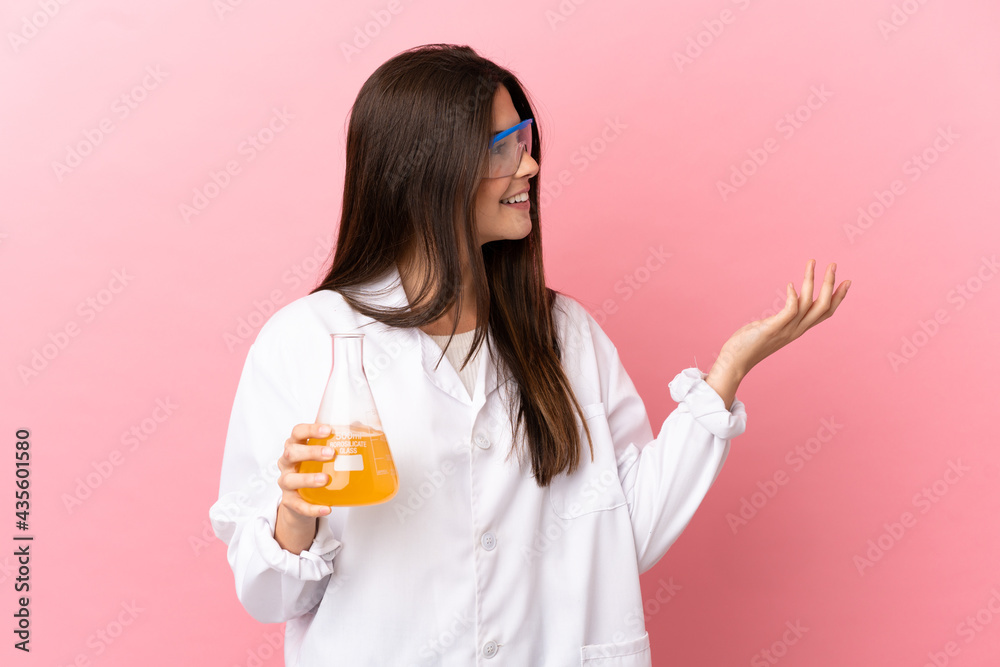 Young scientific girl over isolated pink background extending hands to the side for inviting to come Young scientific girl over isolated pink background extending hands to the side for inviting to come