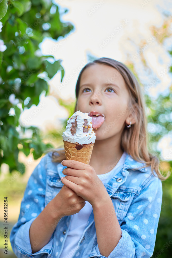 Cute girl with italian ice cream cone smiling and looking at camera while resting in park on summer day, child enjoying ice cream outdoor, happy holidays, summertime Cute girl with italian ice cream cone smiling and looking at camera while resting in park on summer day, child enjoying ice cream outdoor, happy holidays, summertime