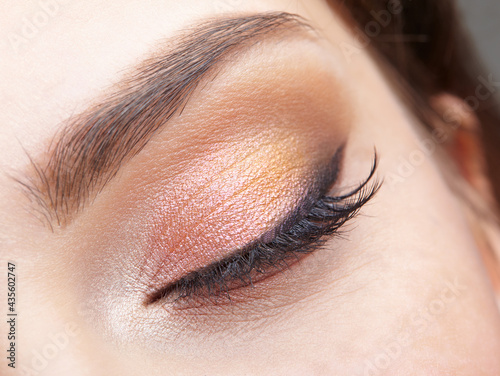 Closeup macro shot of closed human female eye. Girl with perfect skin and  pink eyes shadows