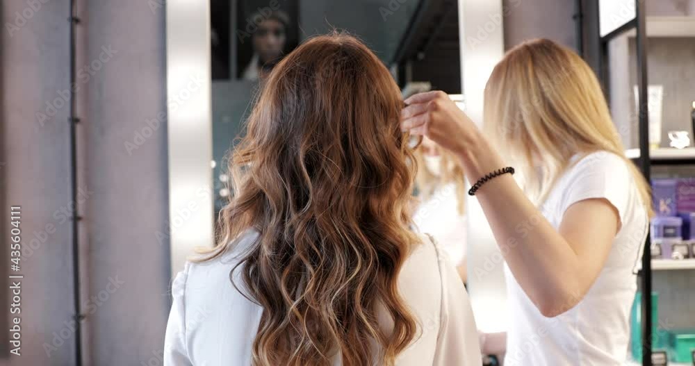 Hairdresser makes curls to young bride in beauty salon. Hairdresser makes curls to young bride in beauty salon.