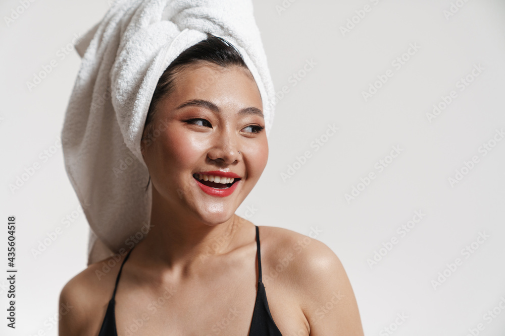 Brunette asian woman wearing swimsuit and towel smiling at camera Brunette asian woman wearing swimsuit and towel smiling at camera