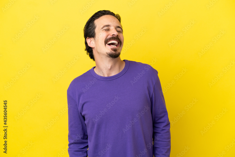 Young caucasian man isolated on yellow background laughing Young caucasian man isolated on yellow background laughing