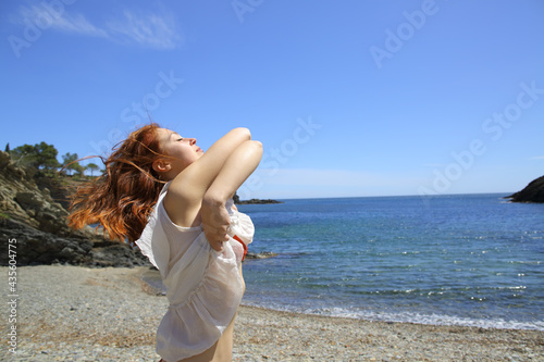 Woman undressing on the beach ready to bath photo
