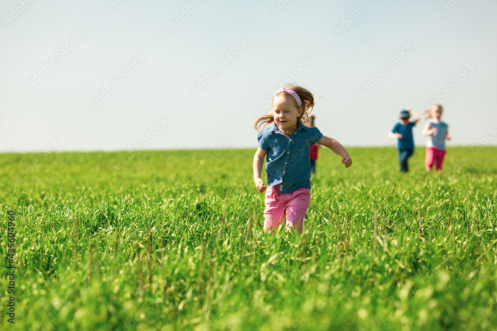 A group of happy children of boys and girls run in the Park on the grass on a Sunny summer day . The concept of ethnic friendship, peace, kindness, childhood A group of happy children of boys and girls run in the Park on the grass on a Sunny summer day . The concept of ethnic friendship, peace, kindness, childhood