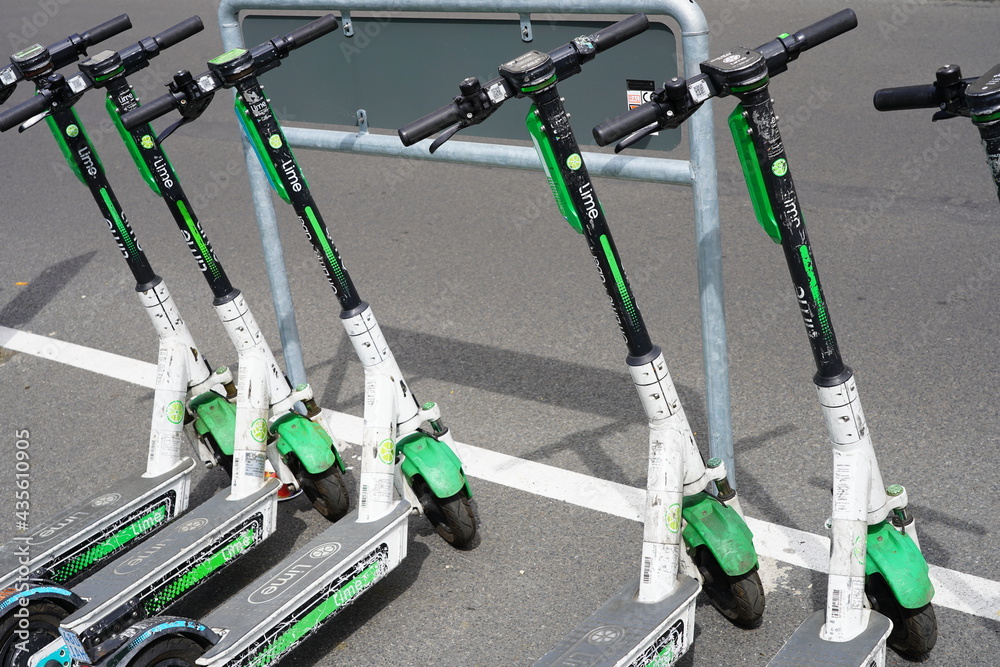 Teilaufnahme mehrere Lime eScooter auf einem Parkplatz bei