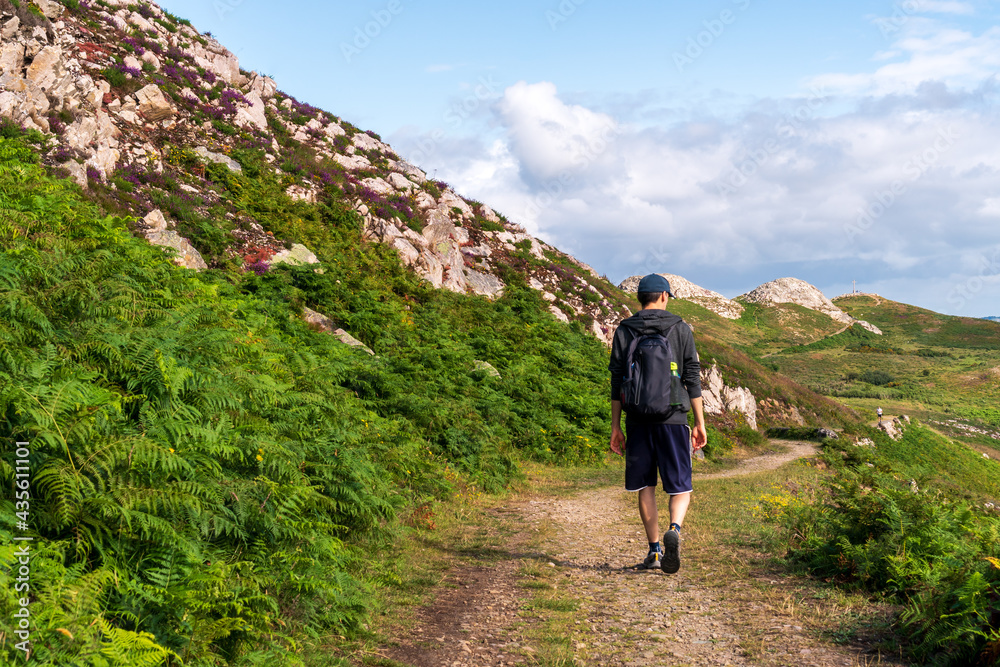 Man hiking in the Irish mountains. Landscape from the Bray Head in Wicklow, Ireland.