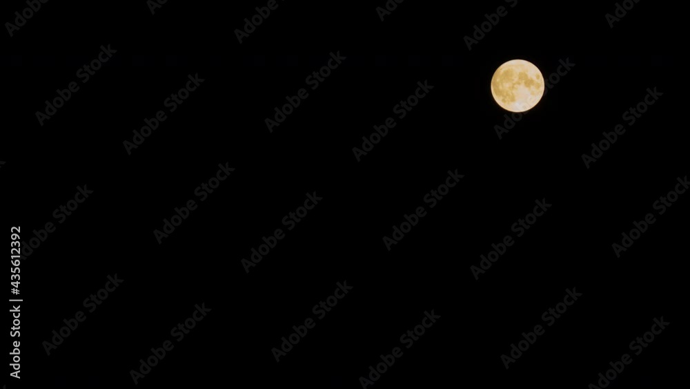 Timelapse - bright orange full moon rising against black clear sky at night. Time lapse, astronomy, supermoon, mystical, halloween, moonrise and nature concept Timelapse - bright orange full moon rising against black clear sky at night. Time lapse, astronomy, supermoon, mystical, halloween, moonrise and nature concept