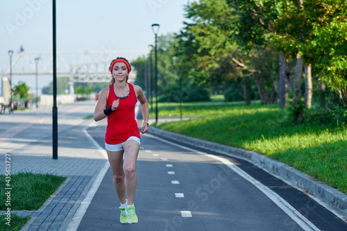 Running Woman on racetrack during training session. Female runner practicing on athletics race track