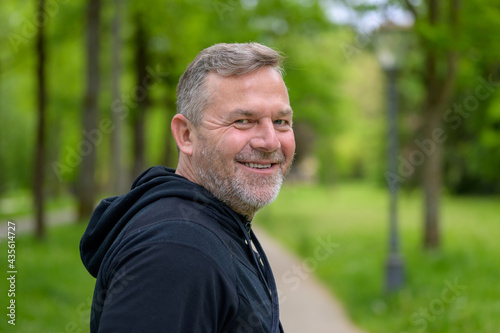 Happy friendly man turning to smile at the camera