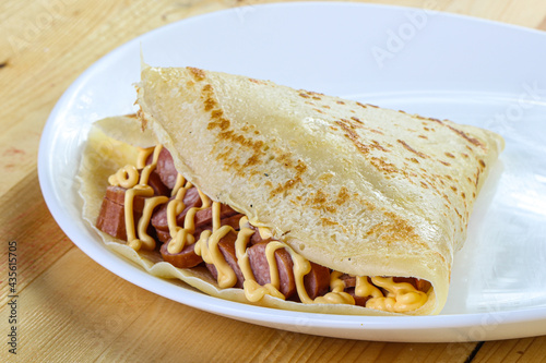 Pancake with sliced sausage and mustard