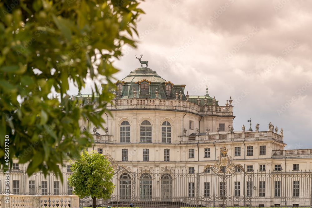 Stupinigi, Turin, Italy: historic royal hunting lodge of the Savoy royal house, selective focus blurred leaves in the foreground