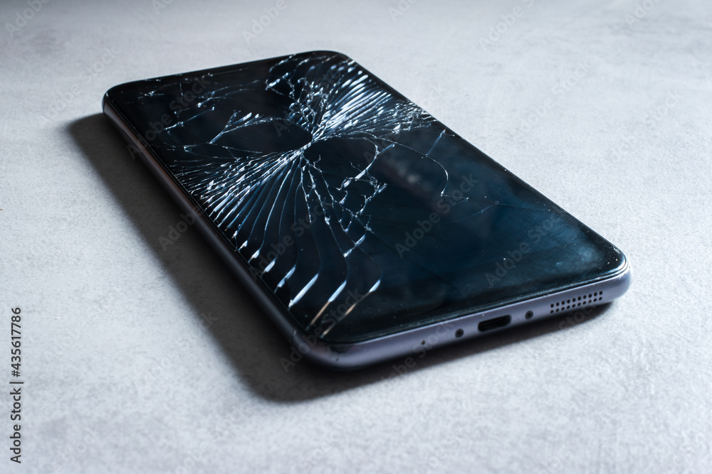 broken smartphone on a gray background broken smartphone on a gray background