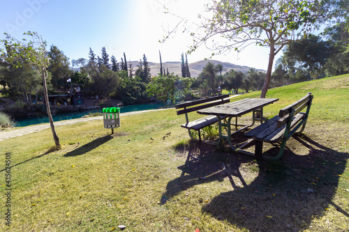 Wooden benches and lawns by the stream in Gan Hashlosha Park in the Springs Valley