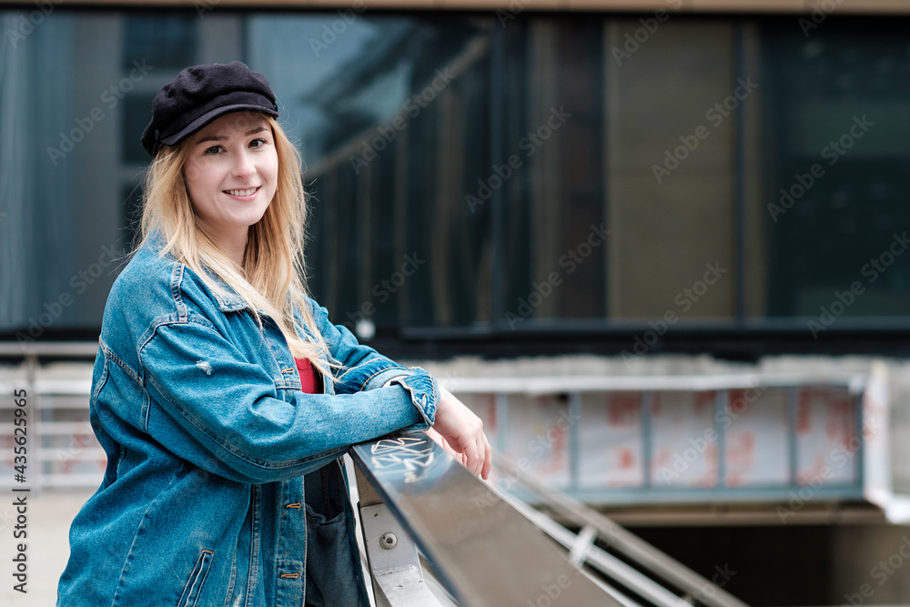 Portrait of young woman leaning on a bridge banister.