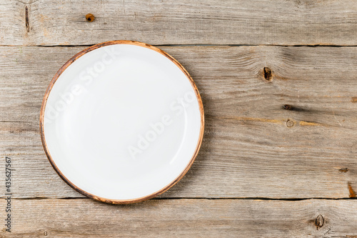 Empty white dish on rustic wooden table