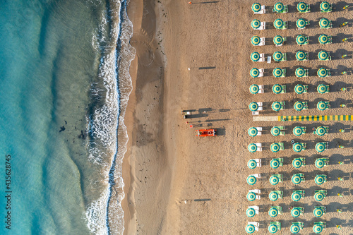 Aerial view of beach umbrellas and sunbeds in tidy rows during summer, Vieste, Foggia province, Gargano, Apulia, Italy photo