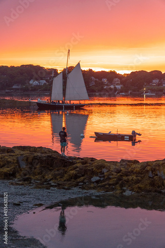 A schooner returns to dock at sunset at Bailey Island, Casco Bay, Maine photo
