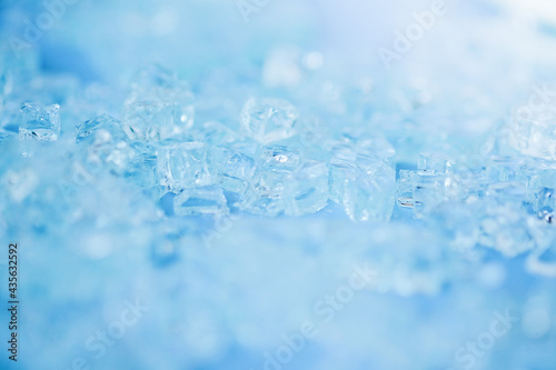 Selective focus,blurred photo of broken pieces of glass on blue background. Abstract minimalistic concept. Space for text .