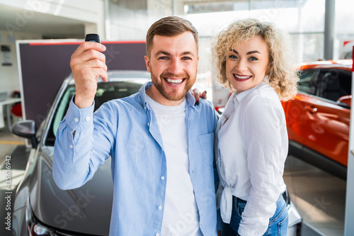Beautiful young couple rejoices buying a new car
