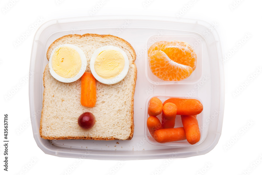 School lunch box snacks for kids over white background. Back to school. Healthy and fun snacks options for parents. Food art creative concepts. Bows with fruits and vegetables and cute face sandwich. School lunch box snacks for kids over white background. Back to school. Healthy and fun snacks options for parents. Food art creative concepts. Bows with fruits and vegetables and cute face sandwich.