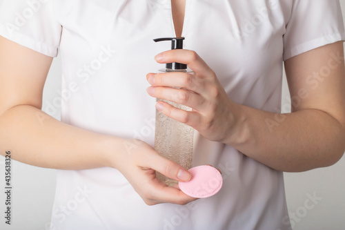 The girl holds in her hands a silicone brush for cleaning the face and gel mousse for skin care, dermatology