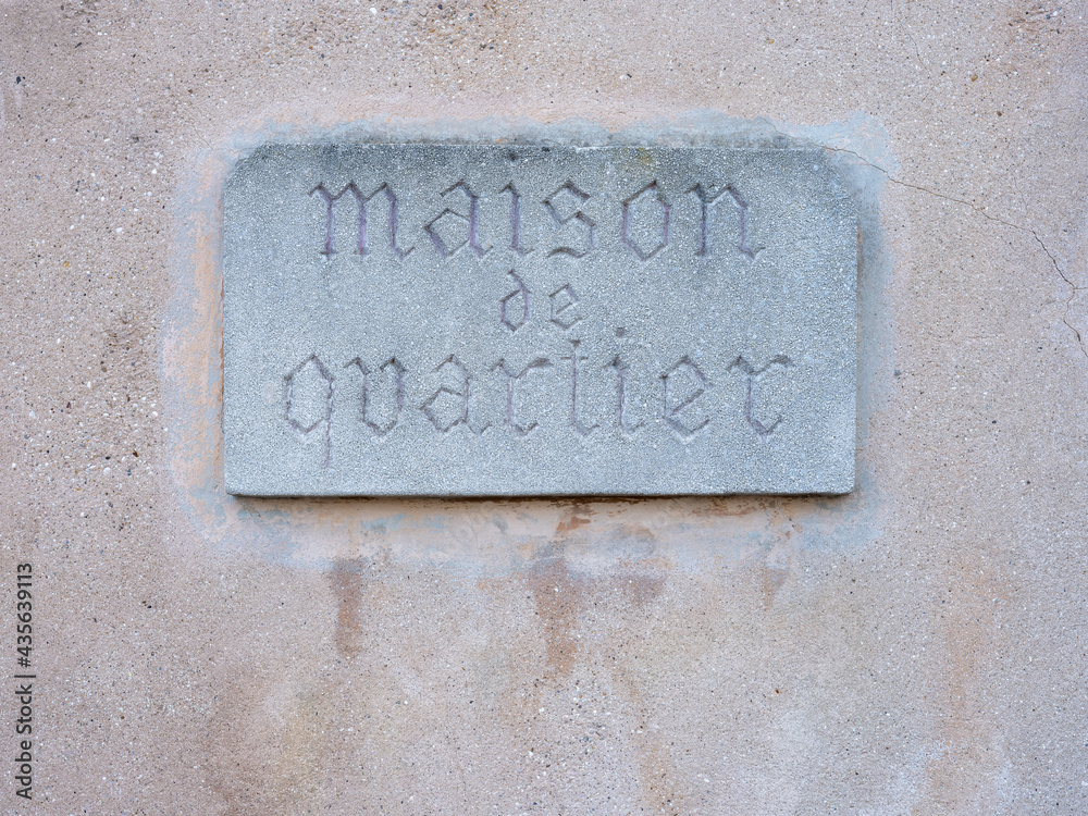 Une plaque en pierre taillée avec écrit dessus Maison de quartier Une plaque en pierre taillée avec écrit dessus Maison de quartier