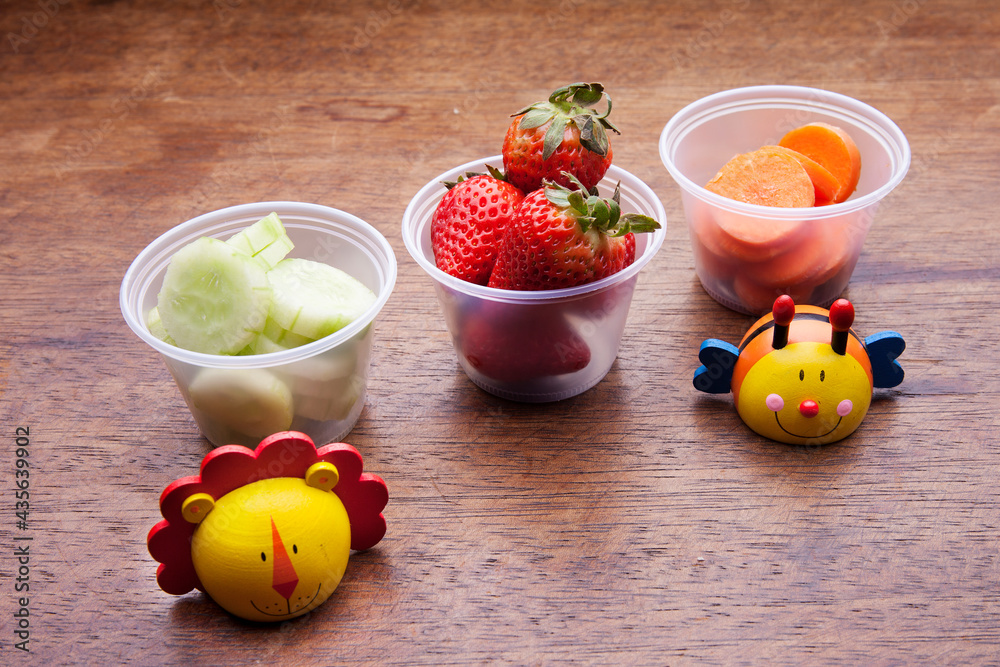 School lunch box snacks for kids over wooden background. Back to school. Healthy and fun snacks options for moms. Cute food art creative concepts. Bows with fruits and vegetables. School lunch box snacks for kids over wooden background. Back to school. Healthy and fun snacks options for moms. Cute food art creative concepts. Bows with fruits and vegetables.
