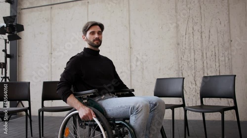 Young man on wheelchair after therapy session, looking at camera. photo