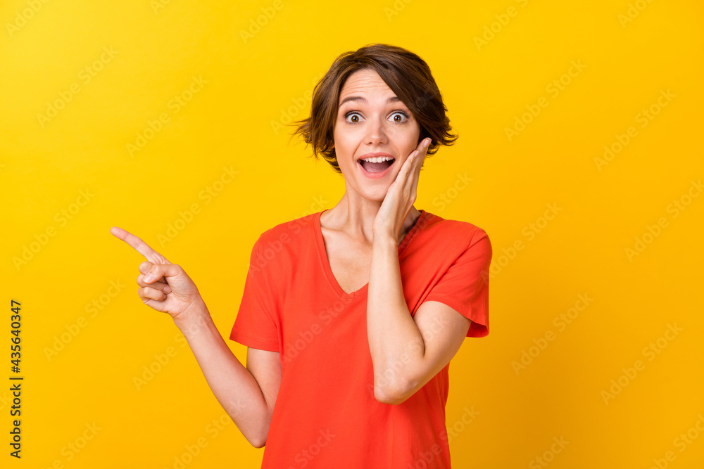 Portrait of nice brunette impressed lady point empty space wear red t-shirt isolated on vivid yellow color background Portrait of nice brunette impressed lady point empty space wear red t-shirt isolated on vivid yellow color background