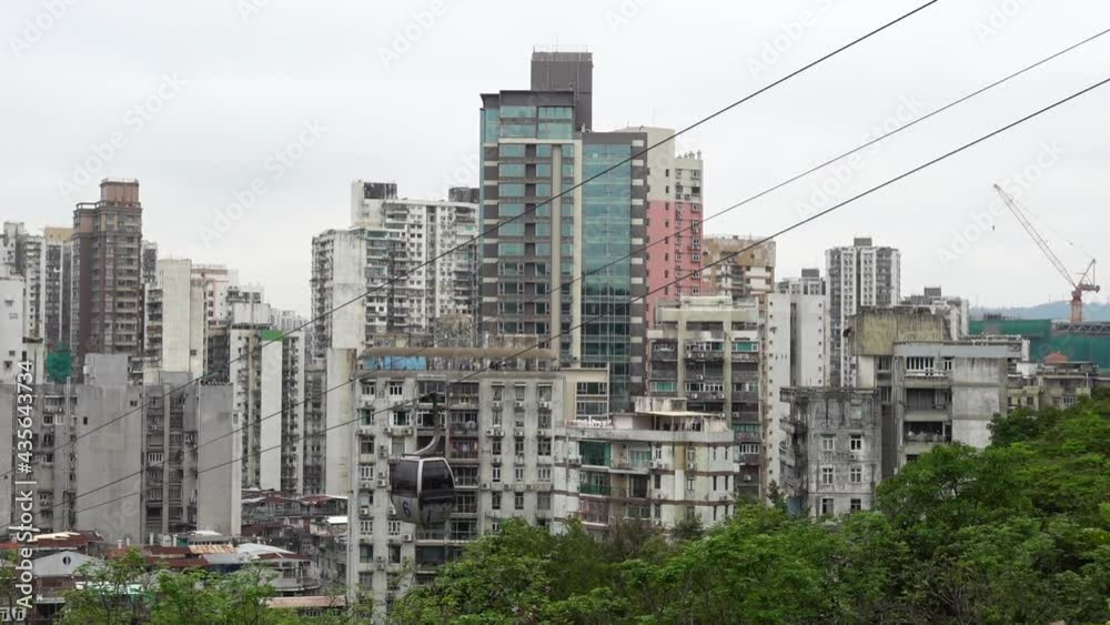 City skyline. Cable car is moving up to the park on mountain at Macau. Beautiful view of Macau city with cable car passing over. City skyline. Cable car is moving up to the park on mountain at Macau. Beautiful view of Macau city with cable car passing over.