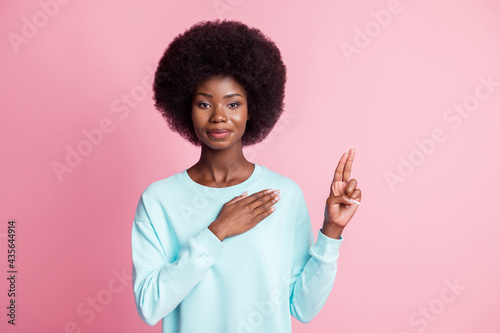 Photo of derious hones dark skin woman hold hand heart two fingers oath pledge isolated on pastel pink color background