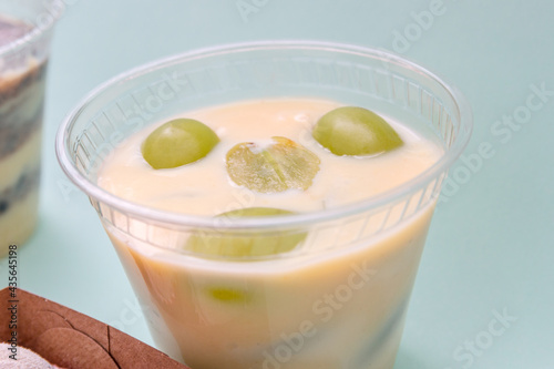 sweet condensed milk with grape in a glass with blue background.