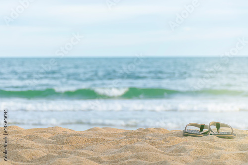 Flip-flops on the sand, on the beach, clear sky, space for text