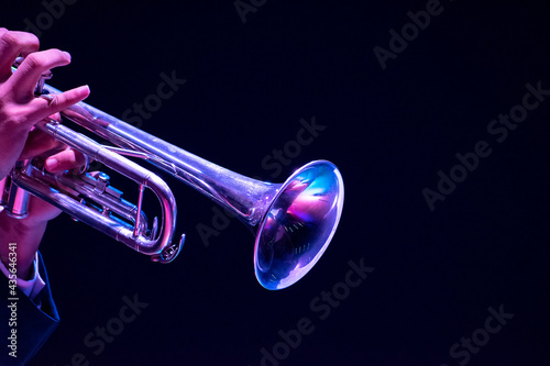 Musician, man playing trumpet, hand close up  black background