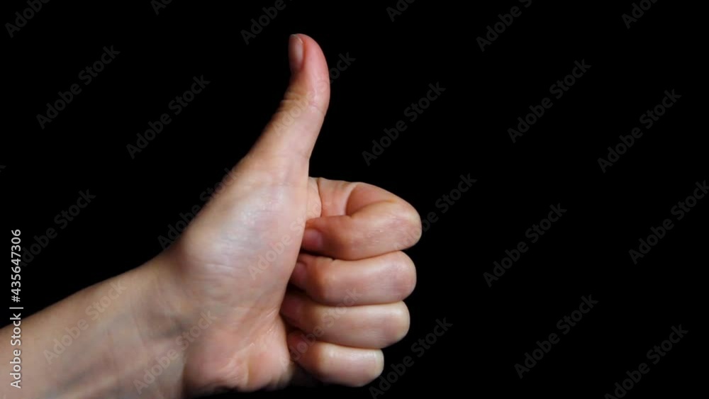 Hand on a black background. Thumbs up. Okay symbol Hand on a black background. Thumbs up. Okay symbol