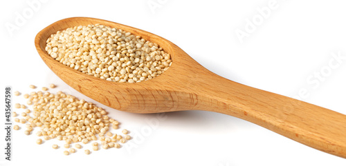 uncooked white quinoa in the wooden spoon, isolated on white background