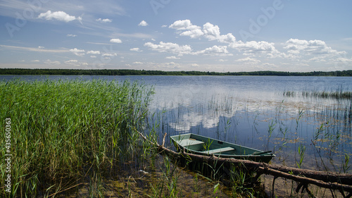 Reeds along the shore of Busnieks lake and boat in Ventspils, Latvia.