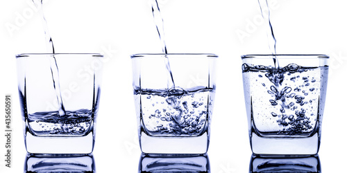 Pour water into three clear glasses with a splash of water. Isolated on white background