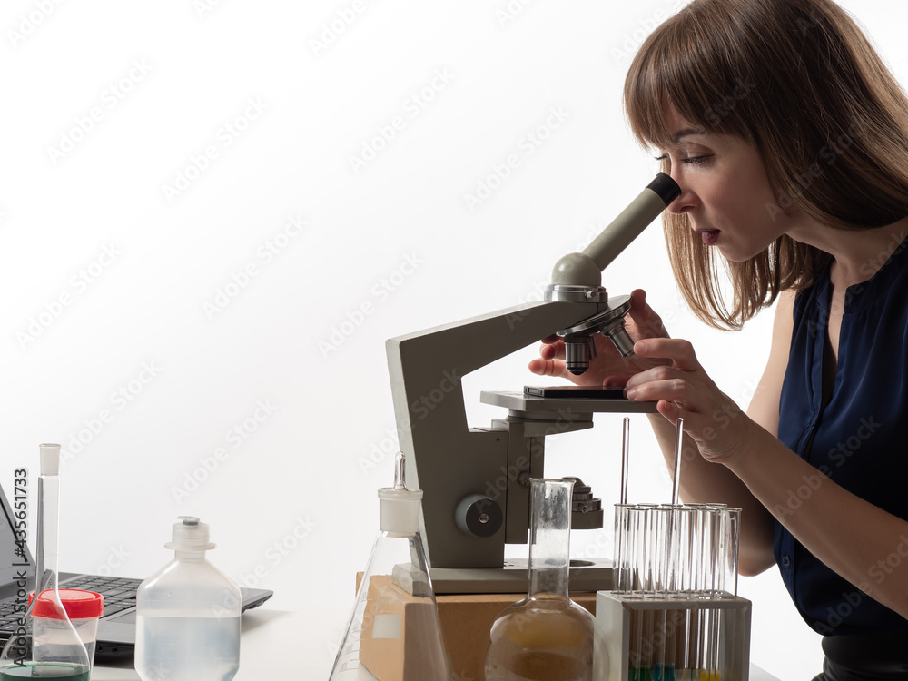Portrait of a laboratory technician with a microscope. Laboratory technician woman in casual clothes. Businesswoman with a microscope. Businesswoman conducts research in the laboratory.