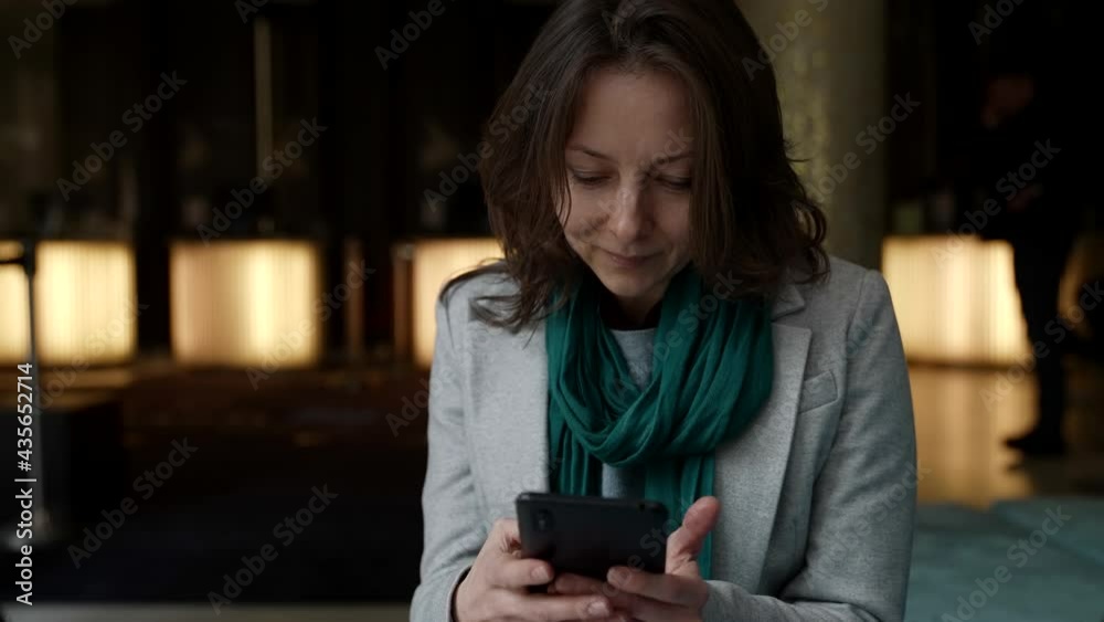 middle aged woman with modern smartphone in public place, medium portrait of lady with gadget